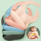 Toddler enjoying self-feeding using a mess-free silicone baby bib during baby-led weaning.