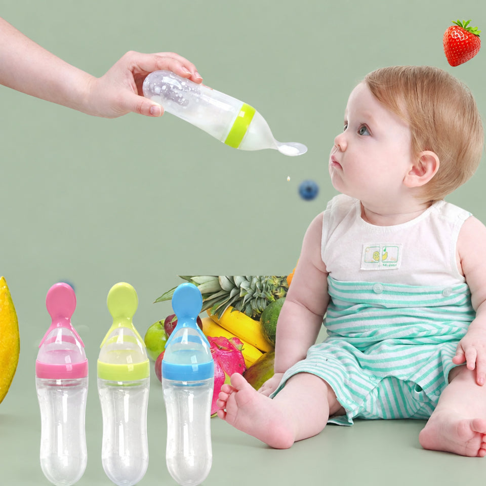 Pink baby squeeze feeding bottle standing upright on a highchair tray using its suction cup base.